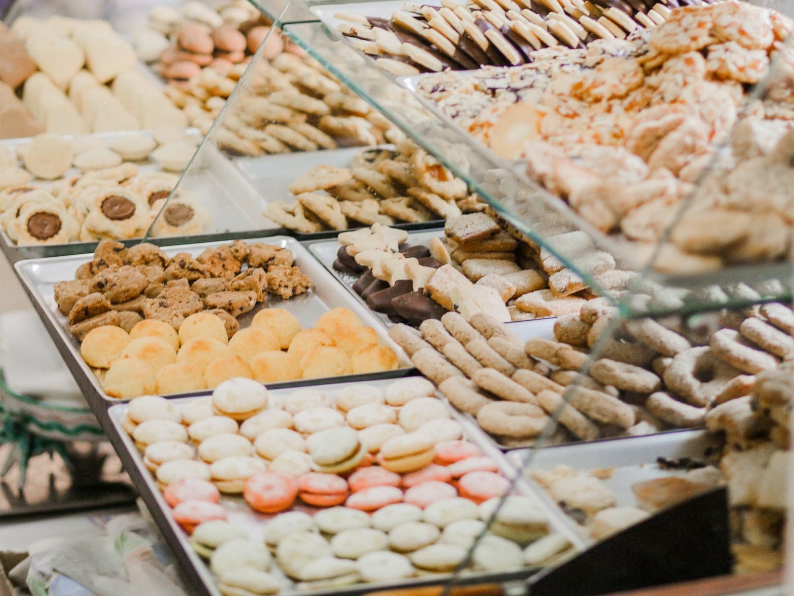Trays of cookies and pastries in a glass bakery display case